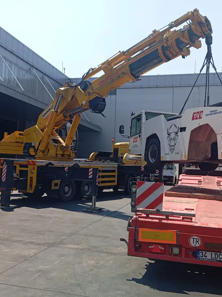 Şantiye alanında iş makinesini kaldıran mobil vinç